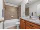 Bathroom features tile surround bathtub, wood vanity, and updated fixtures at 7486 S Washington St, Centennial, CO 80122