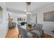 Open dining room with stylish lighting, glass table with seating for six, adjacent to the well lit living room at 7486 S Washington St, Centennial, CO 80122