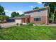 Well-maintained two-story home featuring a red front door and landscaped yard at 7486 S Washington St, Centennial, CO 80122