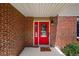 Charming red front door with decorative glass and a 'Home Sweet Home' welcome mat on a brick home's entrance at 7486 S Washington St, Centennial, CO 80122
