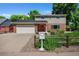 Charming two-story home featuring a well-manicured lawn, brick accents, mature trees, and a welcoming red front door at 7486 S Washington St, Centennial, CO 80122