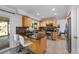Modern kitchen with stainless steel appliances, granite countertops, wood cabinets, and breakfast bar overlooking the dining area at 7486 S Washington St, Centennial, CO 80122