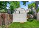 This charming shed is surrounded by greenery and a wooden fence at 7486 S Washington St, Centennial, CO 80122