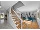 Elegant staircase featuring wooden steps, white risers, and black iron railings leading to the light filled living room at 7486 S Washington St, Centennial, CO 80122