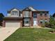 Charming two-story brick home with a well-manicured lawn, attached garage, and lovely architectural details at 1251 N Burlington Dr, Castle Rock, CO 80104