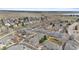 Aerial view of a neighborhood with houses, trees, and a glimpse of a lake in the distance at 11826 W Stanford Pl, Morrison, CO 80465