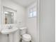 Well lit half bathroom with pedestal sink, white toilet, and window for great natural light at 12682 Anhawa Ave, Longmont, CO 80503