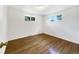 Cozy bedroom with hardwood floors, natural light from two windows, and neutral decor at 12682 Anhawa Ave, Longmont, CO 80503