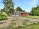 Attractive brick home with a charming enclosed front porch, complemented by meticulously landscaped front yard at 12682 Anhawa Ave, Longmont, CO 80503