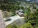 Expansive aerial view showcases a home with a long driveway surrounded by lush trees and scenic landscape at 18170 Forest View Rd, Monument, CO 80132