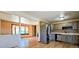 Open-concept room with a large stone fireplace and hardwood flooring adjacent to kitchen at 18170 Forest View Rd, Monument, CO 80132