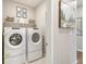 Efficient laundry room with modern Whirlpool appliances and overhead shelving for organized storage solutions at 16113 Alpine Sorrel Dr, Monument, CO 80132