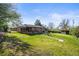 Expansive backyard featuring a well-maintained lawn, mature trees, and a charming brick patio seating area at 3061 S Mabry Ct, Denver, CO 80236