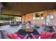 Relaxing covered patio with ample seating, brick accents, and a view of the spacious backyard at 3061 S Mabry Ct, Denver, CO 80236