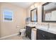 Bathroom featuring double vanities with framed mirrors, toilet, window, and tile flooring at 6210 Wescroft Ave, Castle Rock, CO 80104