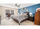 Bedroom featuring a blue accent wall, a large bed with a ceiling fan, and a window view at 6210 Wescroft Ave, Castle Rock, CO 80104
