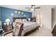 Bedroom featuring a large bed with a blue accent wall and matching lamps on wooden nightstands at 6210 Wescroft Ave, Castle Rock, CO 80104