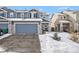 Charming two-story home with a two-car garage and stone accents, surrounded by a snow-covered landscape at 6210 Wescroft Ave, Castle Rock, CO 80104