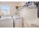 Practical laundry room with modern washer and dryer, shelving, and window for natural light at 6210 Wescroft Ave, Castle Rock, CO 80104