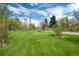 Large grassy backyard features mature trees and lush greenery, creating a serene outdoor space at 4800 S Franklin St, Cherry Hills Village, CO 80113
