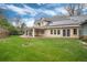 Backyard featuring mature trees, lush green lawns, and a covered patio at 4800 S Franklin St, Cherry Hills Village, CO 80113