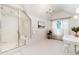 Bright bathroom featuring a glass enclosed shower, a chandelier, and a window for natural light at 4800 S Franklin St, Cherry Hills Village, CO 80113