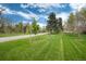Large lush front yard with mature trees and paved driveway leading to the home at 4800 S Franklin St, Cherry Hills Village, CO 80113