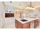 Spacious kitchen with white cabinets, center island with sink, and stainless steel dishwasher at 4800 S Franklin St, Cherry Hills Village, CO 80113