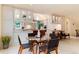 Sunlit kitchen and breakfast nook with white cabinets, island, stainless appliances, and modern chairs at 4800 S Franklin St, Cherry Hills Village, CO 80113