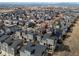Aerial shot of a community with modern townhomes and surrounding landscape, including city and mountains at 8855 E 55Th Ave, Denver, CO 80238