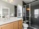 Modern bathroom featuring dark tiled shower, contemporary fixtures, and ample vanity space at 8855 E 55Th Ave, Denver, CO 80238