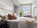 Sunlit bedroom with a comfortable bed, modern decor, and a cozy seating area by the window at 8855 E 55Th Ave, Denver, CO 80238
