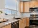 Close-up of the kitchen area with stainless steel appliances, tile backsplash, and granite countertops at 8855 E 55Th Ave, Denver, CO 80238