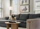 Comfortable living room showcases a plush gray sectional, round wood coffee table, and stylish decor at 8855 E 55Th Ave, Denver, CO 80238