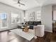 Bright living room with dark wood floors, neutral walls, plush gray sofa, and ceiling fan at 8855 E 55Th Ave, Denver, CO 80238