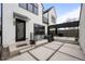 Modern farmhouse exterior with sleek black accents, concrete patio, and outdoor kitchen featuring a grill at 1085 S Cook St, Denver, CO 80209