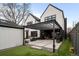Backyard oasis featuring a pergola-covered patio with grill, lush grass, and stylish black and white exterior at 1085 S Cook St, Denver, CO 80209