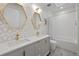 Well-lit bathroom features double vanity with gold fixtures, and shower-tub combo at 1085 S Cook St, Denver, CO 80209