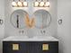 Modern bathroom featuring a double sink vanity with round mirrors, and stylish geometric wallpaper at 1085 S Cook St, Denver, CO 80209