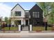 Striking two-tone modern farmhouse exterior with black trim, fenced yard, and manicured lawn at 1085 S Cook St, Denver, CO 80209