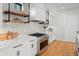 Close-up of the kitchen featuring a gas range, stainless steel appliances, and custom shelving at 1085 S Cook St, Denver, CO 80209