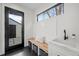 Mudroom with black hexagonal floor tiles, sink, bench, and modern accents at 1085 S Cook St, Denver, CO 80209