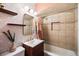 Stunning bathroom featuring geometric wallpaper, wood shelf, and shower/tub combination with tile surround at 60 Vrain St, Denver, CO 80219
