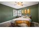 Comfortable bedroom with two windows, green walls, ceiling fan and carpeted floors offers a relaxing space at 60 Vrain St, Denver, CO 80219