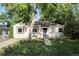 Charming one story home with a well-maintained lawn, lush trees, and quaint front porch at 60 Vrain St, Denver, CO 80219