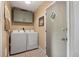 Bright laundry room features a front load washer and dryer, tiled floor, and accent door with glass at 60 Vrain St, Denver, CO 80219