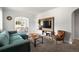 Bright living room featuring a comfortable teal sofa, stylish media center, and an arched entryway to the dining room at 60 Vrain St, Denver, CO 80219