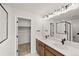 Bathroom featuring a double vanity and a glass shower with black framing at 8777 Whiteclover St, Littleton, CO 80125