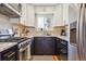 Modern kitchen with stainless steel appliances, black lower cabinets, and white upper cabinets at 1624 S Elizabeth St, Denver, CO 80210