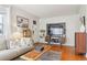 Cozy living room featuring a sofa, modern TV console, and decorative artwork at 1624 S Elizabeth St, Denver, CO 80210